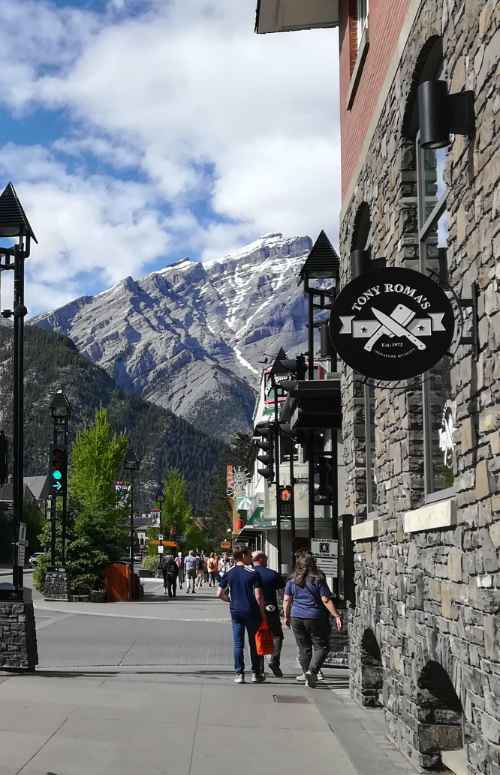 Edificio de piedra en la Banff Avenue con el monte Cascade de fondo.