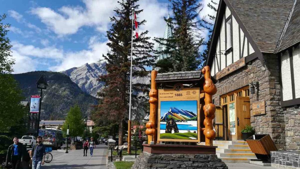 Cartel explicativo del centro de visitantes del parque nacional Banff con las vistas de la montaña de fondo.