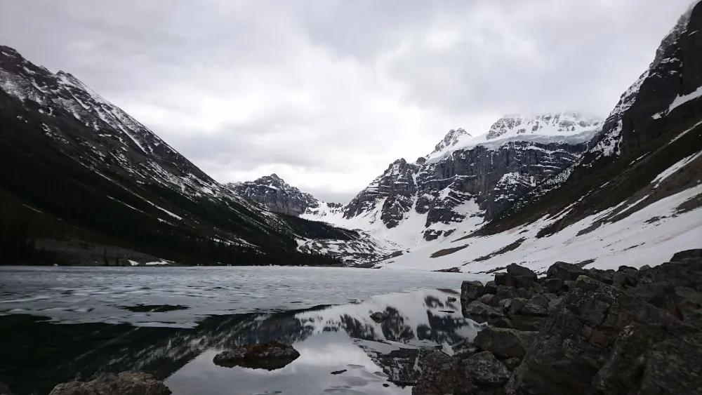 Vista panorámica de Consolation Lakes con montañas nevadas reflejadas en el agua, una ruta de senderismo fácil desde Moraine Lake.