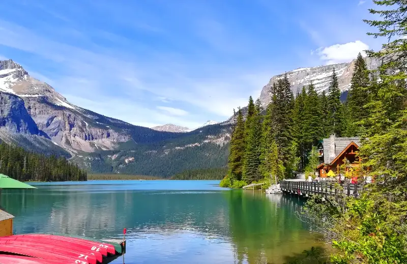 Emerald Lake con el lodge de madera, canoas rojas en el muelle y montañas nevadas al fondo, Yoho
