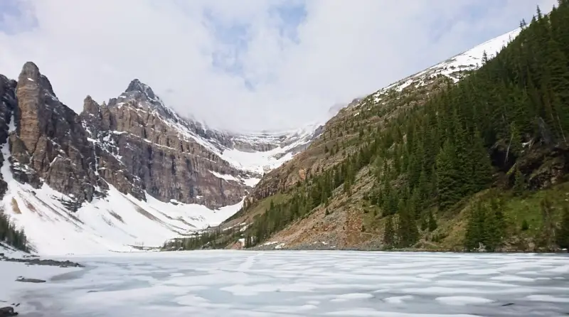 Vista de Lake Agnes congelado y rodeado de picos nevados desde la zona de la Tea House en el Parque Nacional Banff.