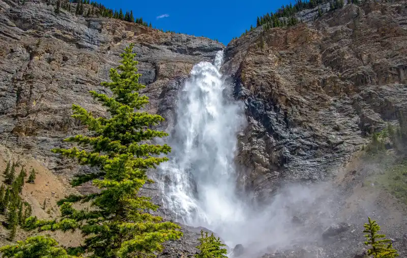 Base de Takakkaw Falls con la bruma del agua y la pared rocosa de cerca en verano